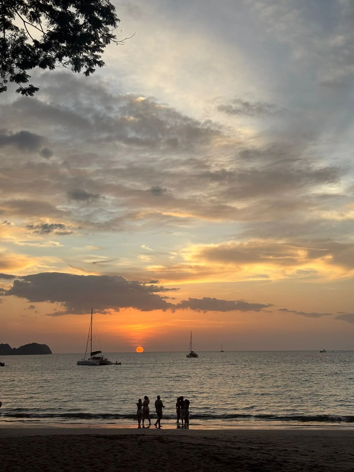 Sailboats and visitors at sunset in Guanacaste